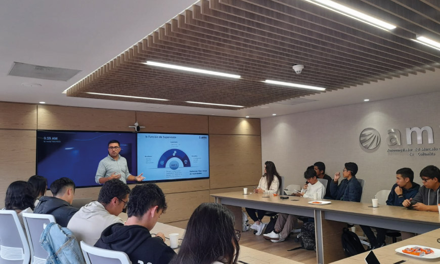 Profesor exponiendo a grupo de estudiantes en mesa redonda