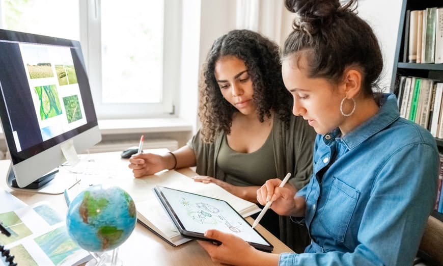 Dos mujeres estudiando, viendo una tablet