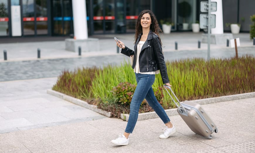 joven caminando con maleta de viaje